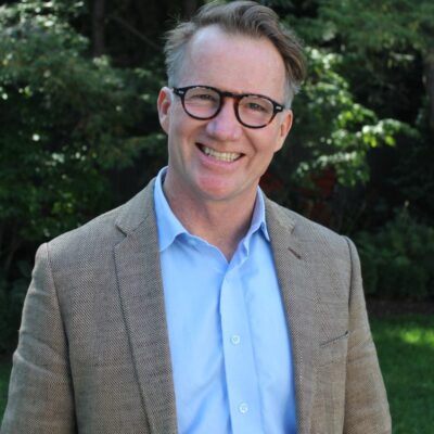 man in gray suit jacket wearing eyeglasses